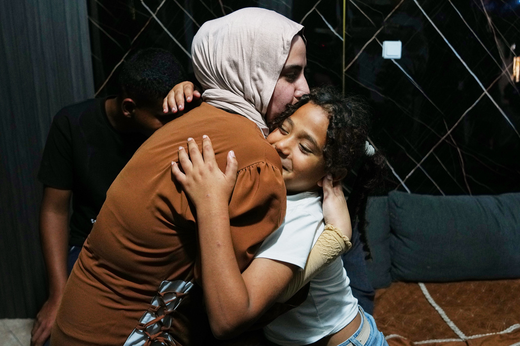 Mais Al-Gharam hugs her 8-year-old sister Arjwan, who was granted an Israeli passport, in her home in Nazareth, Israel, Wednesday, July 8, 2026, after Arjwan's arrival from the Gaza Strip. (AP Photo/Mahmoud Illean)