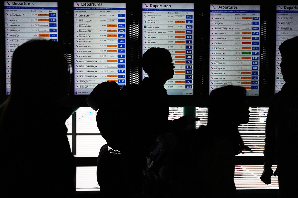 Travelers walk though the terminal at O'Hare International Airport, in Chicago, Sunday, Nov. 30, 2025. (AP Photo/Nam Y. Huh)