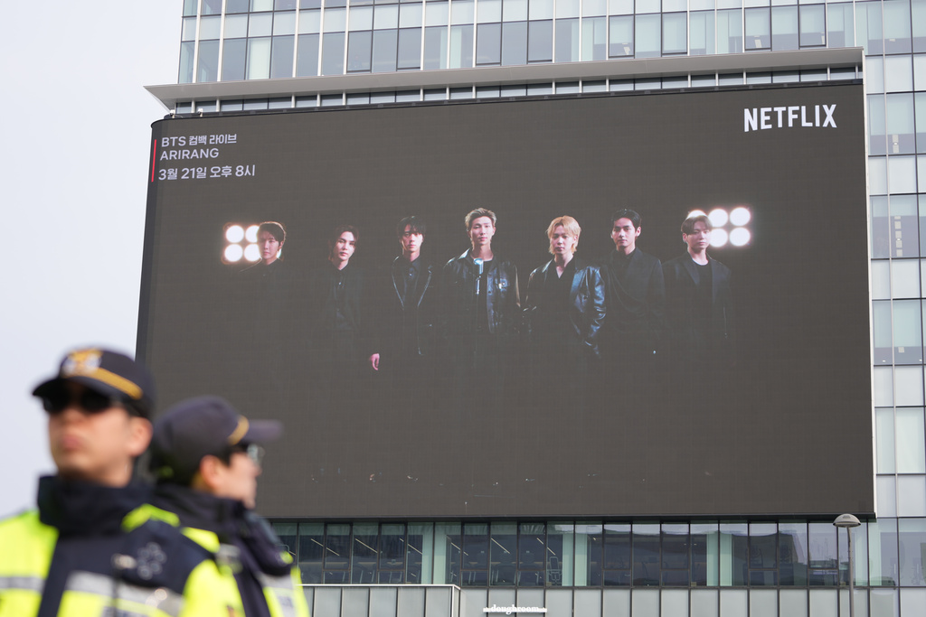 South Korean police officers stand near a billboard showing K-pop band BTS in Seoul, South Korea, Wednesday, March 11, 2026. (AP Photo/Lee Jin-man)