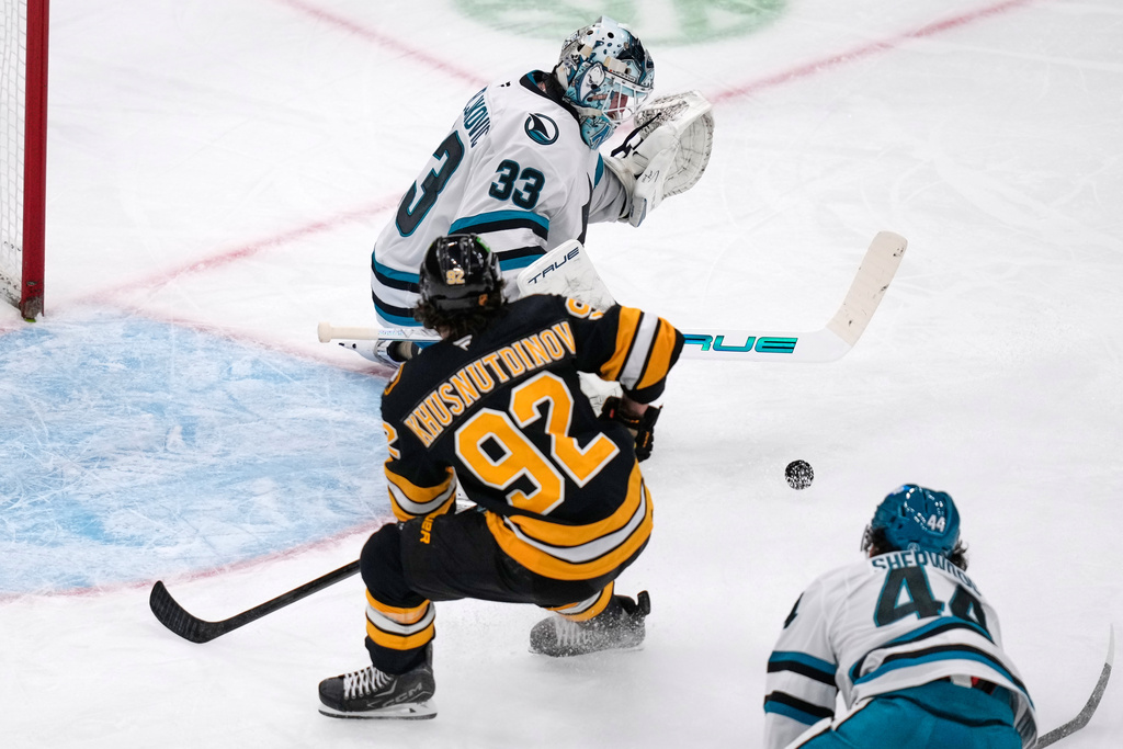San Jose Sharks goaltender Alex Nedeljkovic (33) makes a save as Boston Bruins center Marat Khusnutdinov (92) looks for the rebound during the second period of an NHL hockey game, Thursday, March 12, 2026, in Boston. (AP Photo/Charles Krupa)