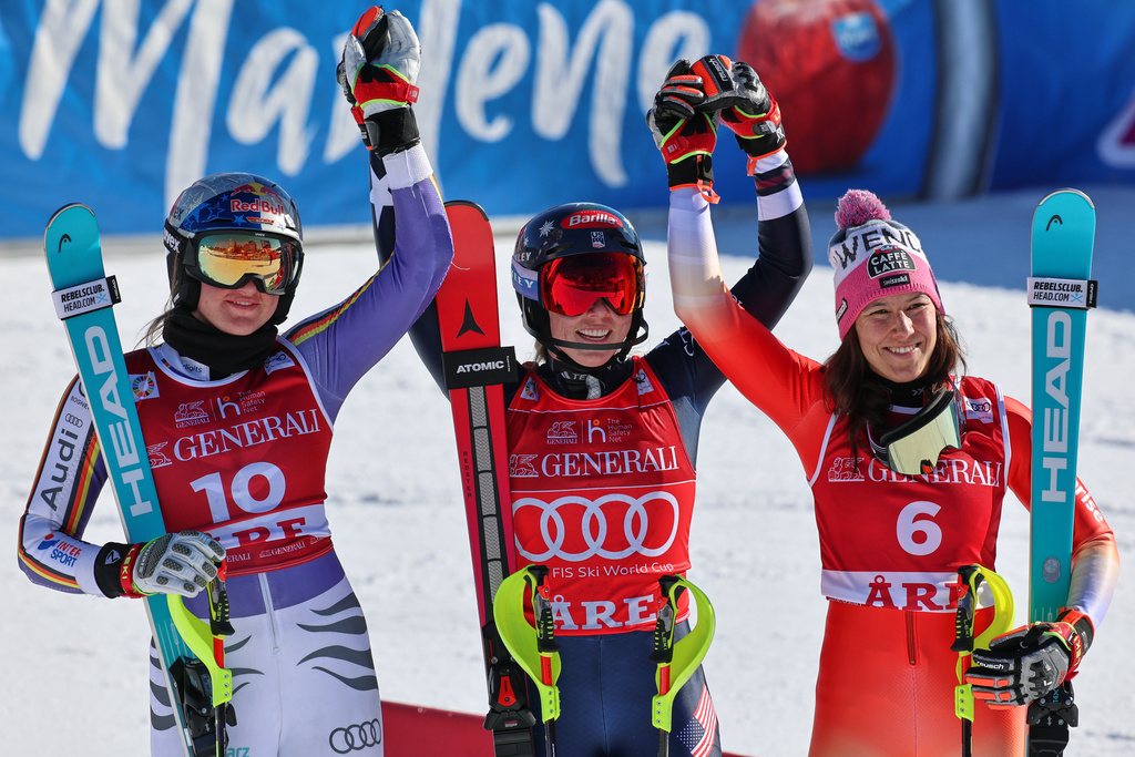 United States' Mikaela Shiffrin, center, winner of an alpine ski, women's World Cup slalom, poses with second placed Germany's Emma Aicher, left, and third placed Switzerland's Wendy Holdener, in Are, Sweden, Sunday, March 15, 2026. (AP Photo/Marco Trovati)