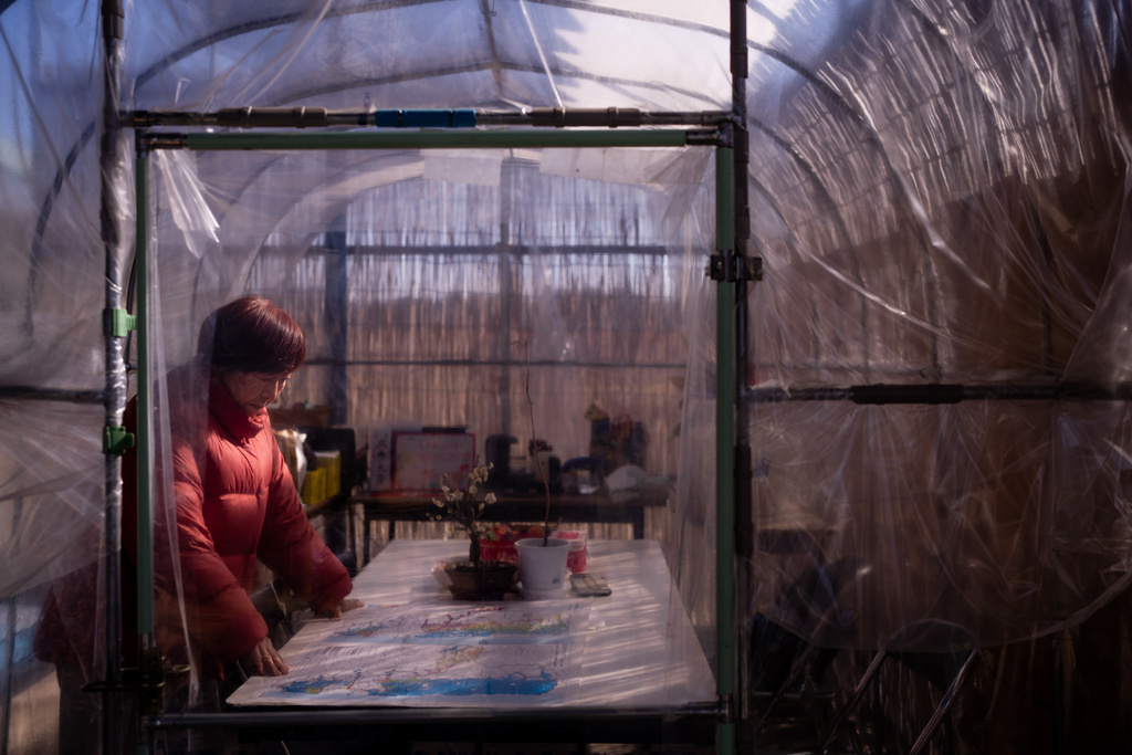 Tomoko Kobayashi looks at a color-coded map of radiation levels created by local residents during an interview near a radiation monitoring lab in Odaka, Friday, Feb. 13, 2026. (AP Photo/Louise Delmotte)