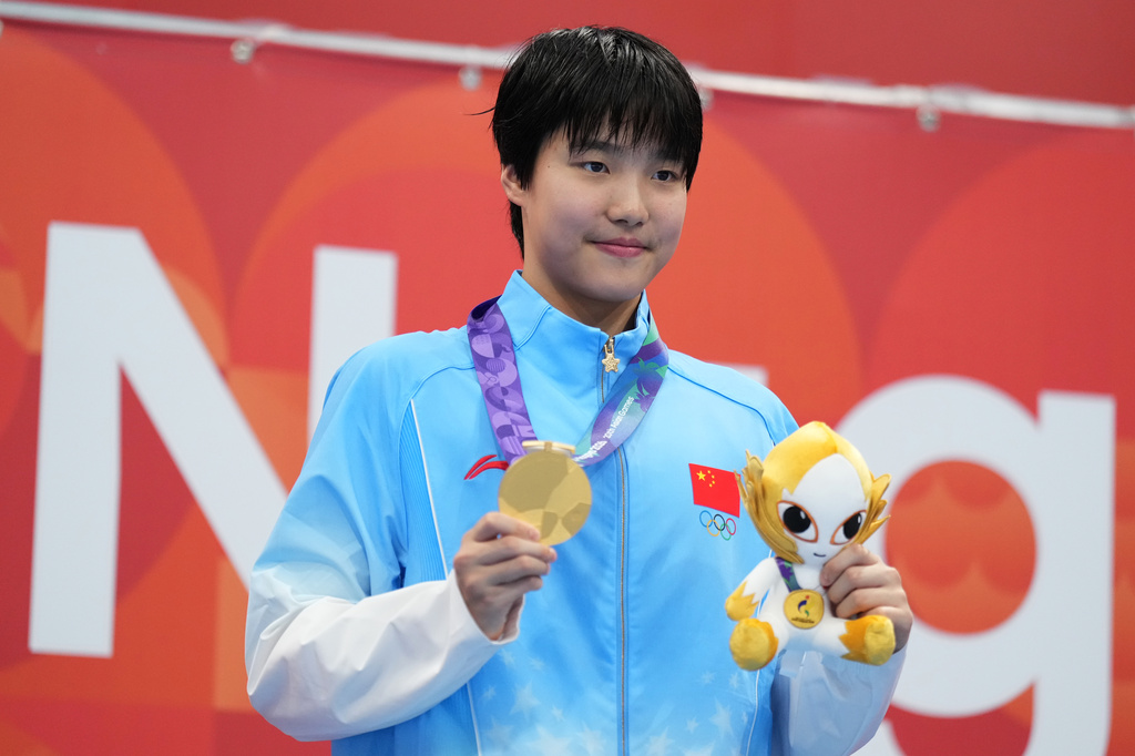 Gold medalist Yu Zidi of China poses on the podium after the women's 200-meter individual medley final in swimming at the Asian Games in Tokyo, Japan, Monday, Sept. 21, 2026. (AP Photo/Hiro Komae)