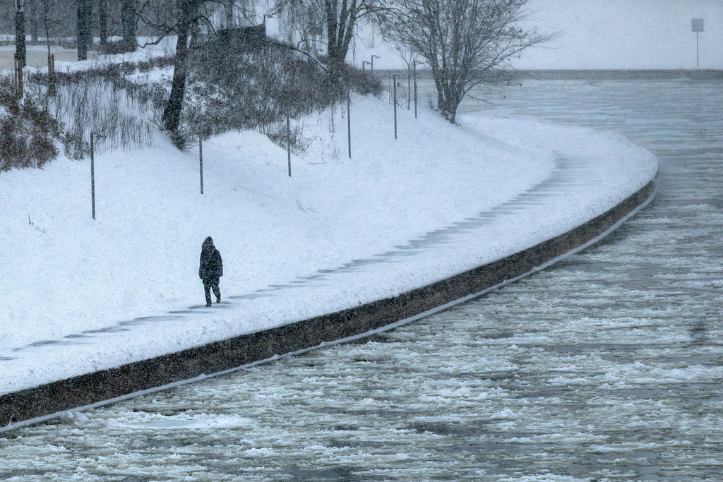 A pedestrian walks along the banks of the Neris river as temperatures dipped to -12 degrees Celsius (10,4 degrees Fahrenheit) in Vilnius, Lithuania, Friday, Jan. 9, 2026. (AP Photo/Mindaugas Kulbis)