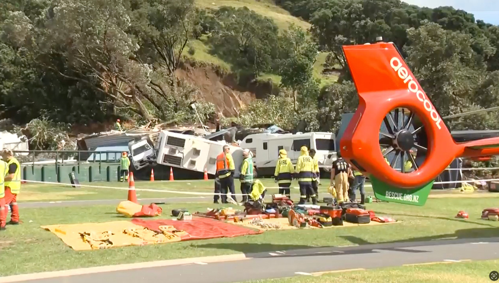 In this image from a video, rescuers and fire crews work near the site of a landslide at the base of Mount Maunganui on New Zealand’s North Island, Thursday, Jan. 22, 2026. (TVNZ via AP)