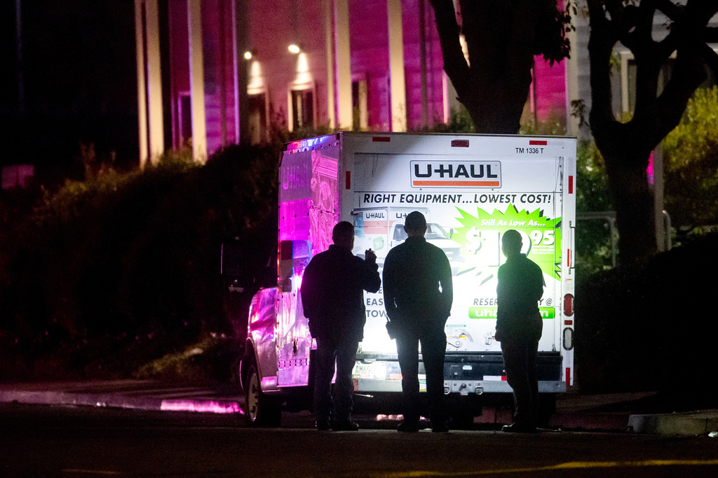 Police officers examine a U-Haul truck involved in a shooting at the entrance to Coast Guard Base Alameda, according to an officer at the scene, Friday, Oct. 24, 2025, in Oakland, Calif. (AP Photo/Noah Berger)