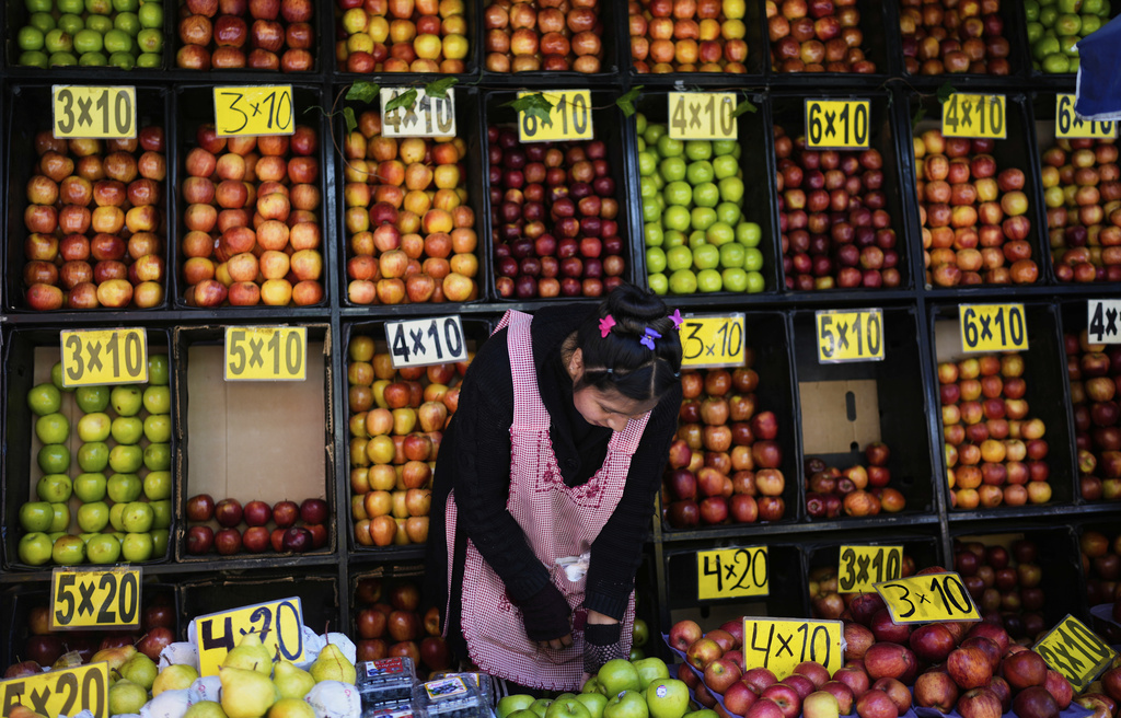 A vendor selling apples waits for customers at a street market in La Paz, Bolivia, Friday, Aug. 8, 2025. (AP Photo/Juan Karita)