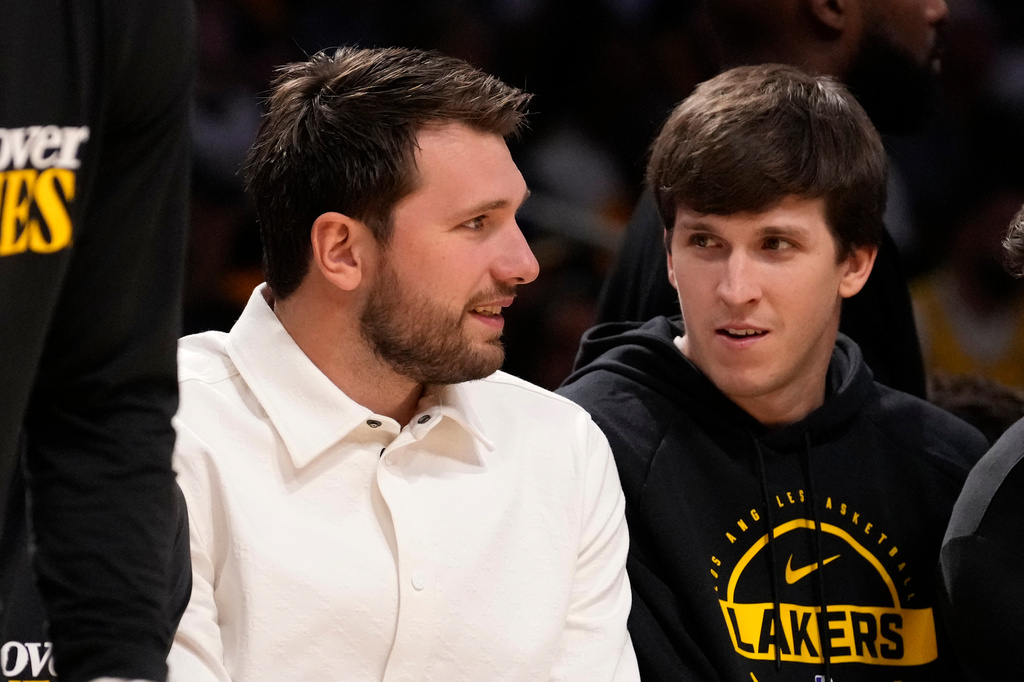 Los Angeles Lakers' Luka Doncic, left, and Austin Reaves chat as they sit on the bench during the second half in Game 1 of a first-round NBA playoffs basketball series against the Houston Rockets, Saturday, April 18, 2026, in Los Angeles. (AP Photo/Mark J. Terrill)