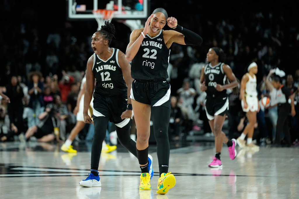 Las Vegas Aces center A'ja Wilson (22) and Las Vegas Aces guard Chelsea Gray (12) celebrate after a play against the Indiana Fever during overtime in Game 5 of a WNBA basketball playoff semifinals series Tuesday, Sept. 30, 2025, in Las Vegas. (AP Photo/John Locher)