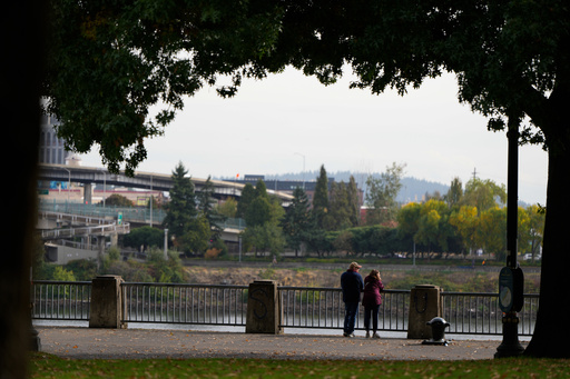 People pause to look out at the Willamette River as they walk along Waterfront Park Trail on Thursday, Oct. 9, 2025, in Portland, Ore. (AP Photo/Jenny Kane) People pause to look out at the Willamette River as they walk along Waterfront Park Trail on Thursday, Oct. 9, 2025, in Portland, Ore. (AP Photo/Jenny Kane)