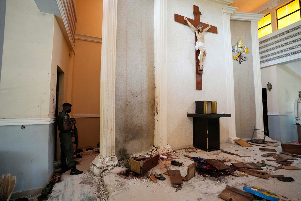FILE - A police officer stands guard inside the St. Francis Catholic Church, a day after an attack that targeted worshipers in Owo, Nigeria, June 6, 2022. (AP Photo/Sunday Alamba, File)