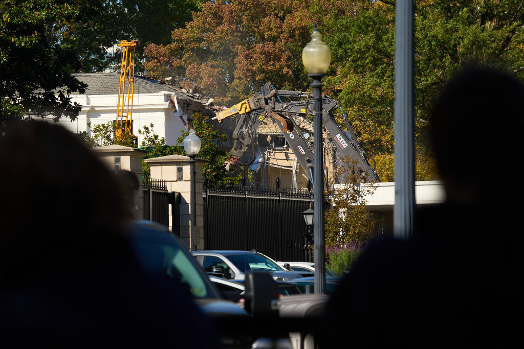 People watch as work continues on the demolition of a part of the East Wing of the White House, Tuesday, Oct. 21, 2025, in Washington, before construction of a new ballroom. (AP Photo/Jacquelyn Martin)