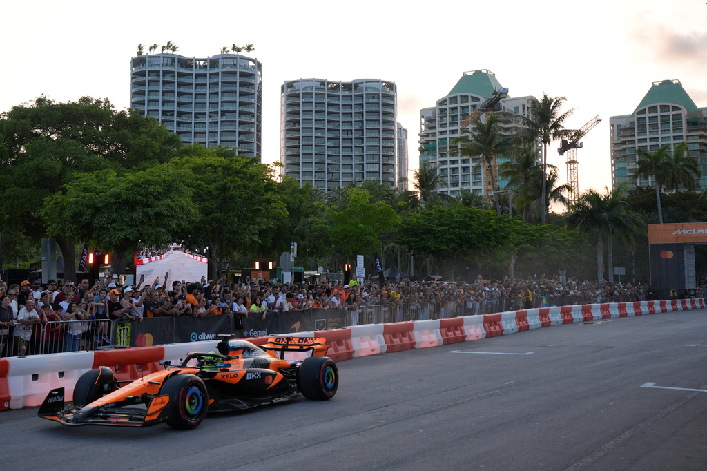 Fans line the edges of the street as McLaren driver Lando Norris of Britain drives an MCL60 during a fan event showcasing past McLaren cars, ahead of the Formula One Miami Grand Prix auto race, Wednesday, April 29, 2026, in the Coconut Grove area of Miami. (AP Photo/Rebecca Blackwell)