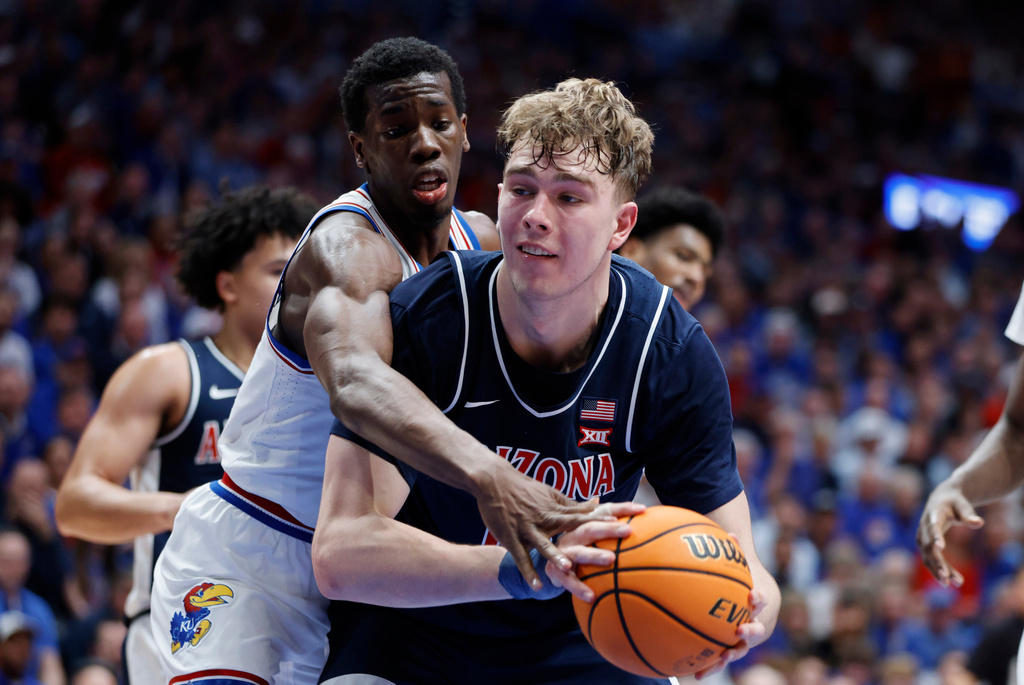 Arizona center Motiejus Krivas, right, grabs a rebound as Kansas guard Melvin Council Jr., left, defends during the first half of an NCAA college basketball game, Monday, Feb. 9, 2026, in Lawrence, Kan. (AP Photo/Colin E. Braley)