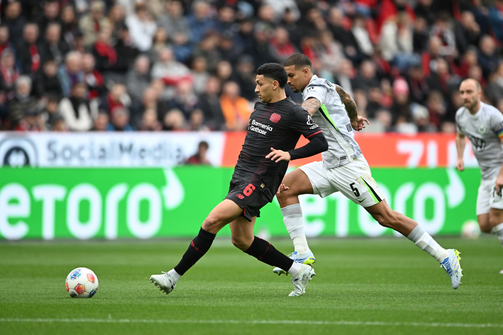 Leverkusen's Ezequiel Fernández, left, and Wolfsburg's Vinicius de Souza Costa in action during the Bundesliga soccer match between Bayer Leverkusen and VfL Wolfsburg in Leverkusen, Germany, Saturday April 4, 2026. (Fabian Strauch/dpa via AP)