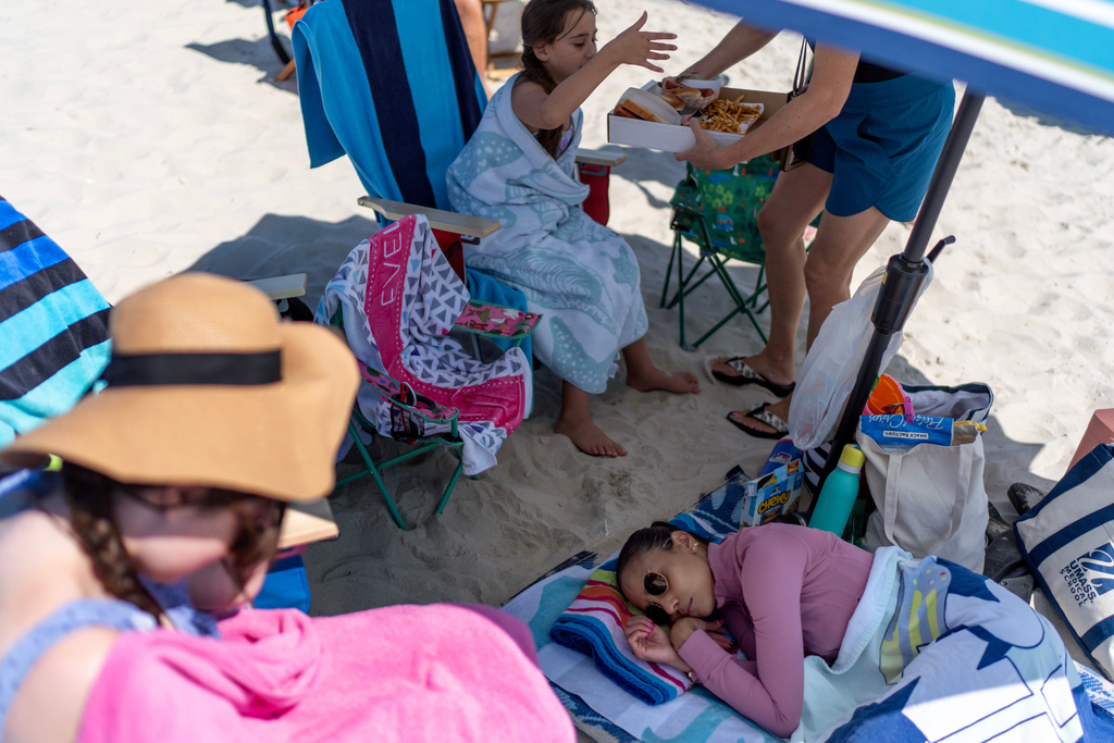 Ruth Wilson, who has lupus, takes a nap after the onset of a migraine and fatigue, as too much sunshine is one of her triggers, while at the beach with family, Saturday, Aug. 16, 2025, in South Yarmouth, Mass. (AP Photo/David Goldman)