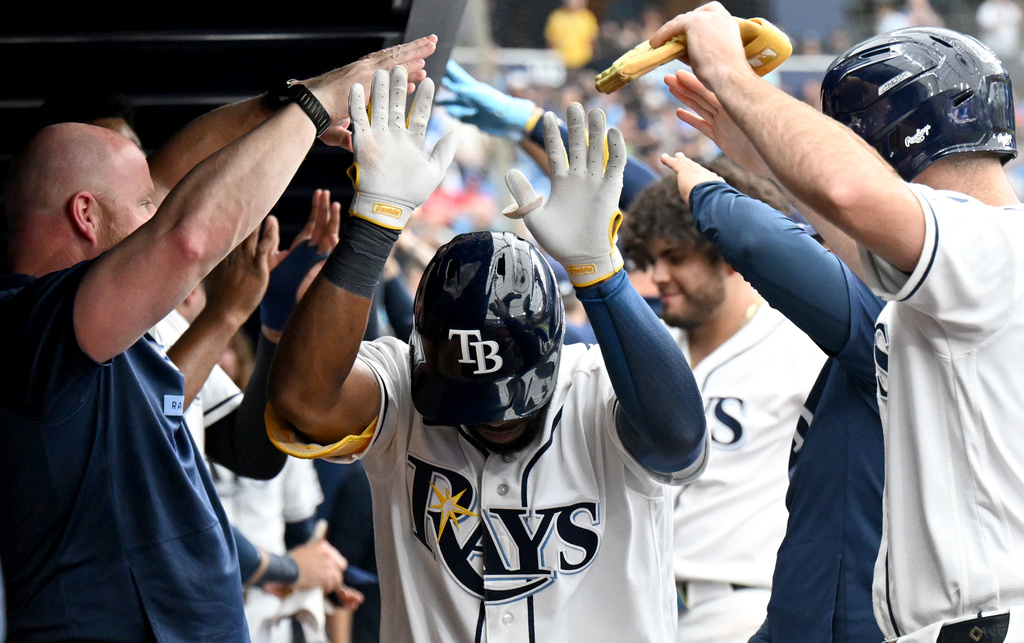 Tampa Bay Rays' Cedric Mullins is greeted in the dugout after hitting a home run during the eighth inning of a baseball game against the Texas Rangers, Thursday, July 30, 2026, in St. Petersburg, Fla. (AP Photo/Jason Behnken)