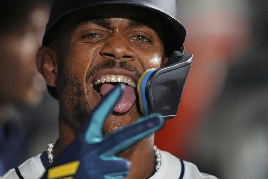 Seattle Mariners' Julio Rodriguez poses in the dugout after scoring on an RBI sacrifice fly from teammate Eugenio Suarez against the Chicago White Sox during the seventh inning of a baseball game Wednesday, Aug. 6, 2025, in Seattle. (AP Photo/Lindsey Wasson)