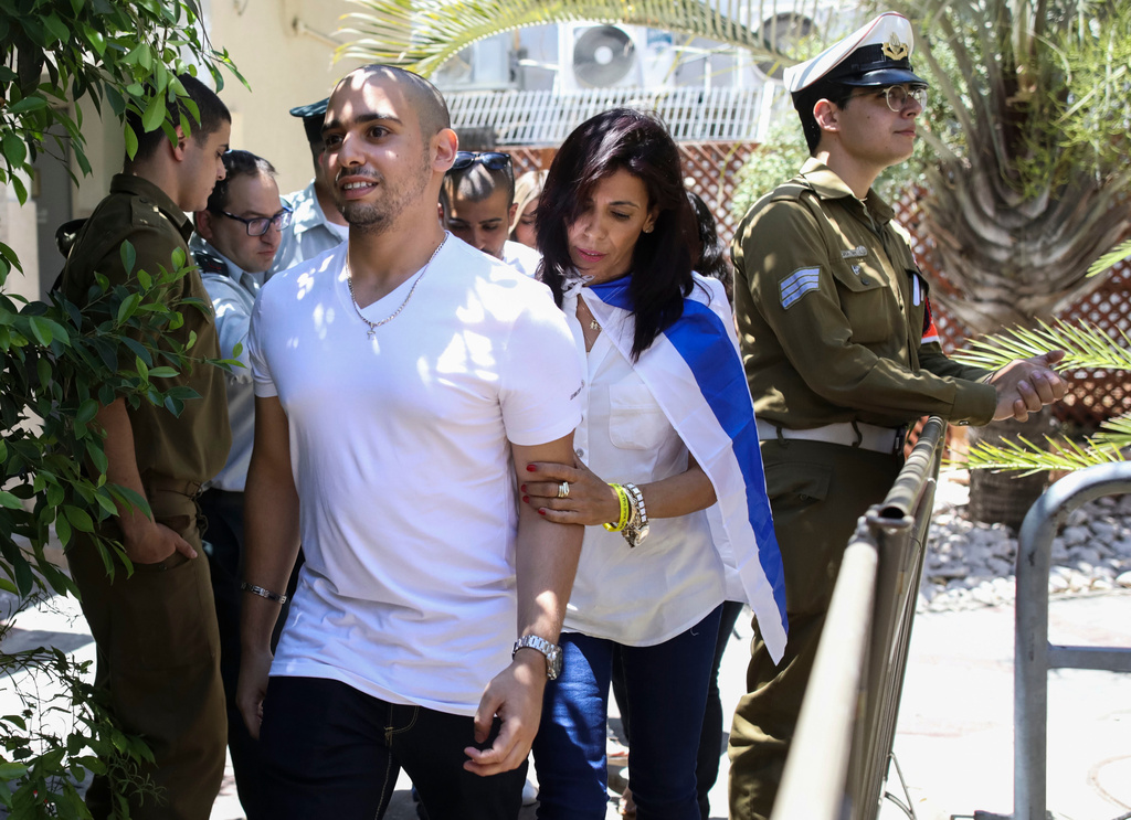 FILE - Elor Azaria escorted by his mother arrives to Israeli military court on July 30, 2017, in Tel Aviv, Israel. (AP Photo/Dan Balilty, Pool, File)