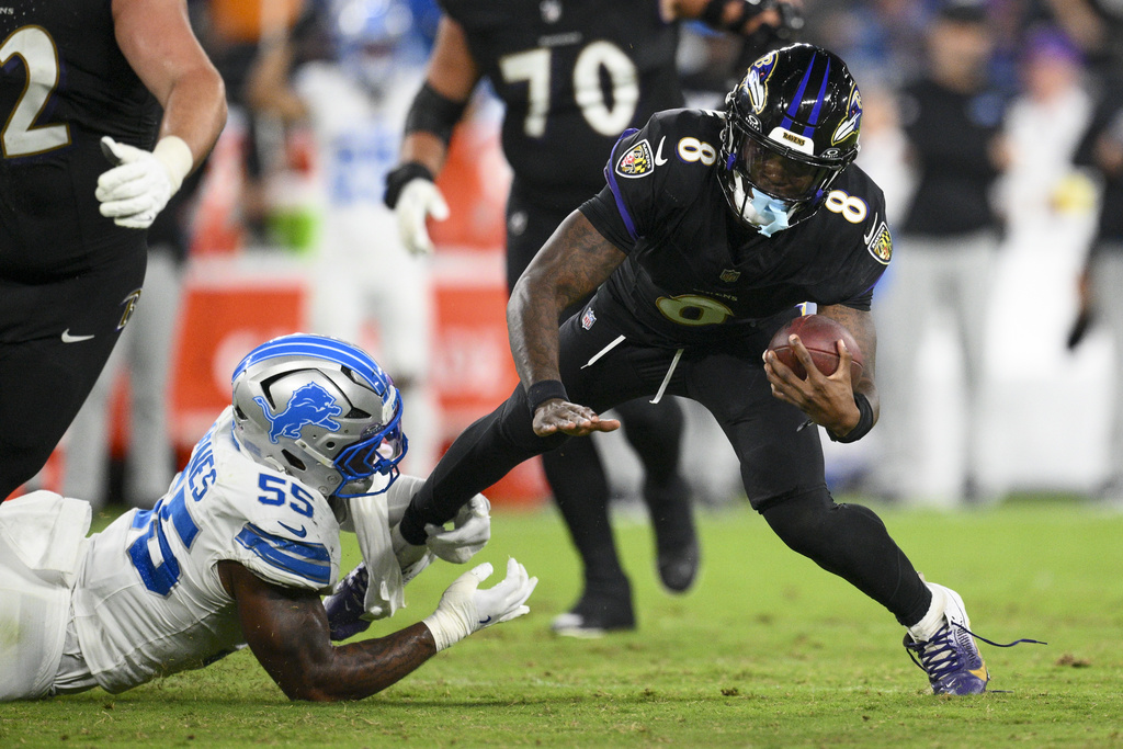 Baltimore Ravens quarterback Lamar Jackson (8) is tripped up by Detroit Lions linebacker Derrick Barnes (55) during the second half of an NFL football game Monday, Sept. 22, 2025, in Baltimore. (AP Photo/Nick Wass)
