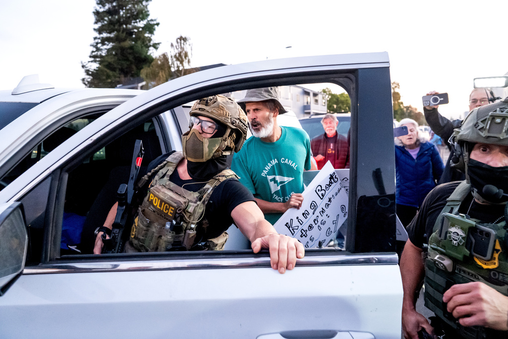 Protesters confront U.S. Border Patrol personnel as they try to enter Coast Guard Base Alameda on Thursday, Oct. 23, 2025, in Oakland, Calif. (AP Photo/Noah Berger)