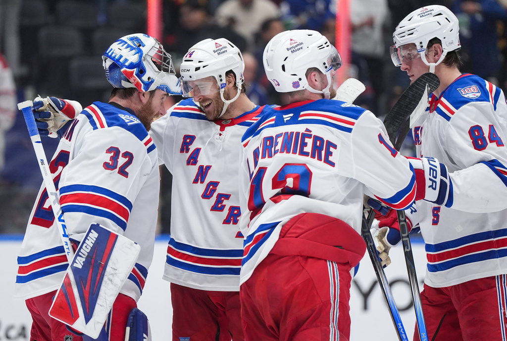 New York Rangers goalie Jonathan Quick, from left to right, Taylor Raddysh, Alexis Lafreniere and Adam Edstrom celebrate after New York defeated the Vancouver Canucks 2-0 during an NHL hockey game, in Vancouver, on Tuesday, Oct. 28, 2025. (Darryl Dyck/The Canadian Press via AP)