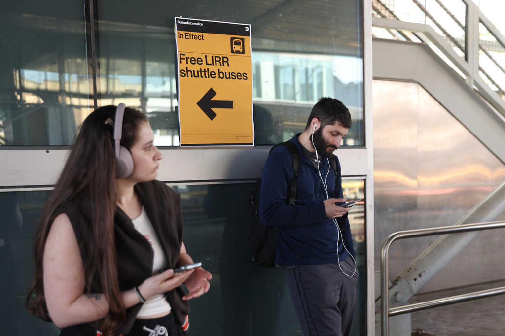 Signs for free Long Island Rail Road shuttle buses hang at the Howard Beach–JFK Airport station as Long Island Rail Road workers enter the third day of their strike, Monday, May 18, 2026, in New York. (AP Photo/Heather Khalifa)