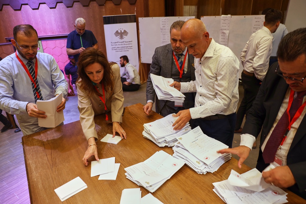Officials count the votes of electoral college members in a parliamentary election at a polling station in Aleppo, Syria, Sunday, Oct. 5, 2025. (AP Photo/Omar Albam)