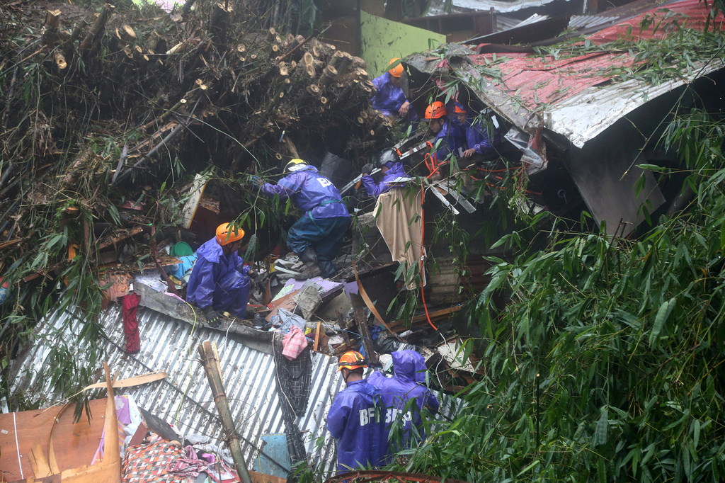 Rescuers conduct search and rescue operations for missing residents a day after several houses were buried from a landslide due to heavy monsoon rains in Guisad Surong, Baguio City, northern Philippines, Monday, Aug. 10, 2026. (AP Photo/Harley Palangchao)
