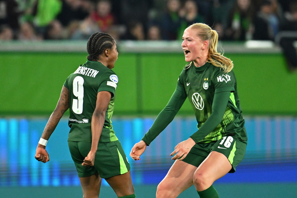 Wolfburg's Lineth Beerensteyn, left, celebrates after scoring with teammate Camilla Kuever during their Champions League quarter-finals, first leg soccer match in Wolfsburg, Germany, Tuesday, March 24, 2026. (Swen Pfortner/dpa via AP)