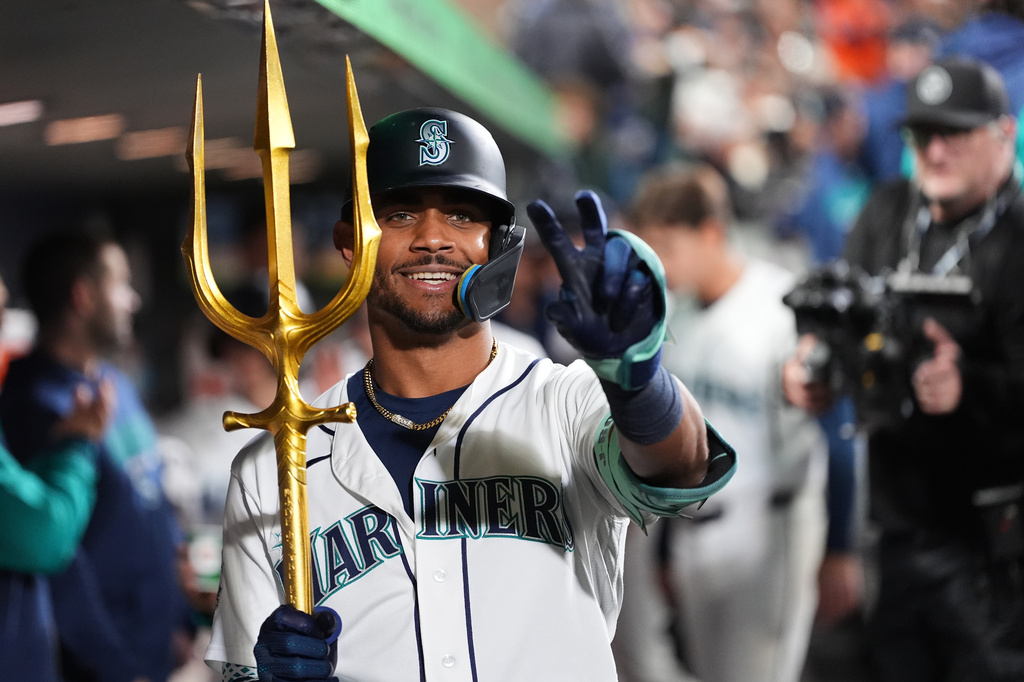 Seattle Mariners' Julio Rodríguez celebrates with the trident in the dugout after hitting a two-run home run against the Houston Astros during the fifth inning of a baseball game, Saturday, April 11, 2026, in Seattle. (AP Photo/Lindsey Wasson)