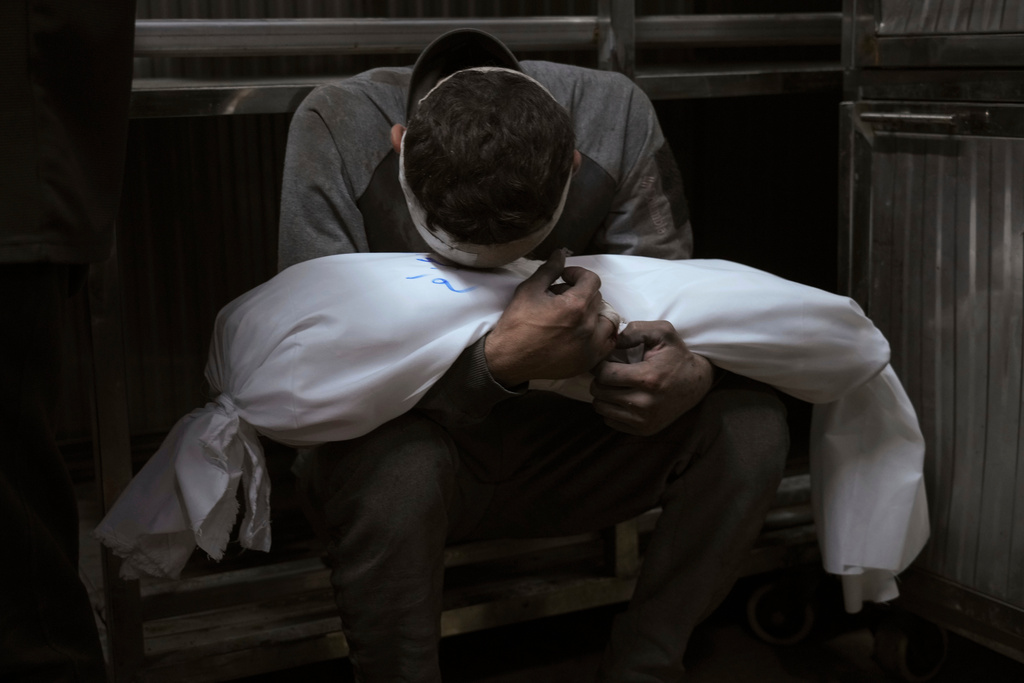 Hossam Azzam holds the body of his child, Amir, who was killed in an Israeli military airstrike on Gaza, at Shifa Hospital in Gaza City Tuesday, July 15, 2025. (AP Photo/Jehad Alshrafi)