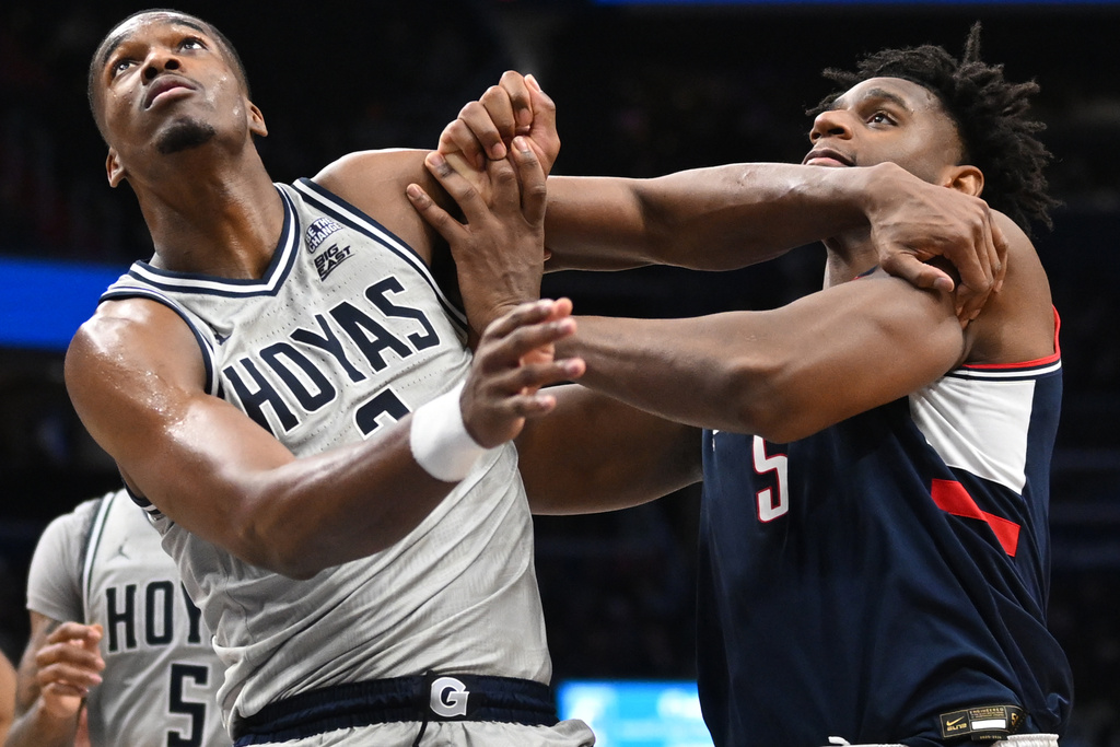 Georgetown center Vincent Iwuchukwu, left, and UConn forward Tarris Reed Jr. vie for a rebound during the second half of an NCAA men's basketball game, Saturday, Jan. 17, 2026, in Washington. (AP Photo/John McDonnell)