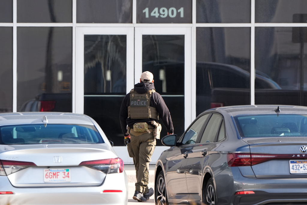 FILE - An ICE agent stands outside a warehouse as federal officials tour the facility to consider repurposing it as an ICE detention facility, Jan. 15, 2026, in Kansas City, Mo. (AP Photo/Charlie Riedel, file)