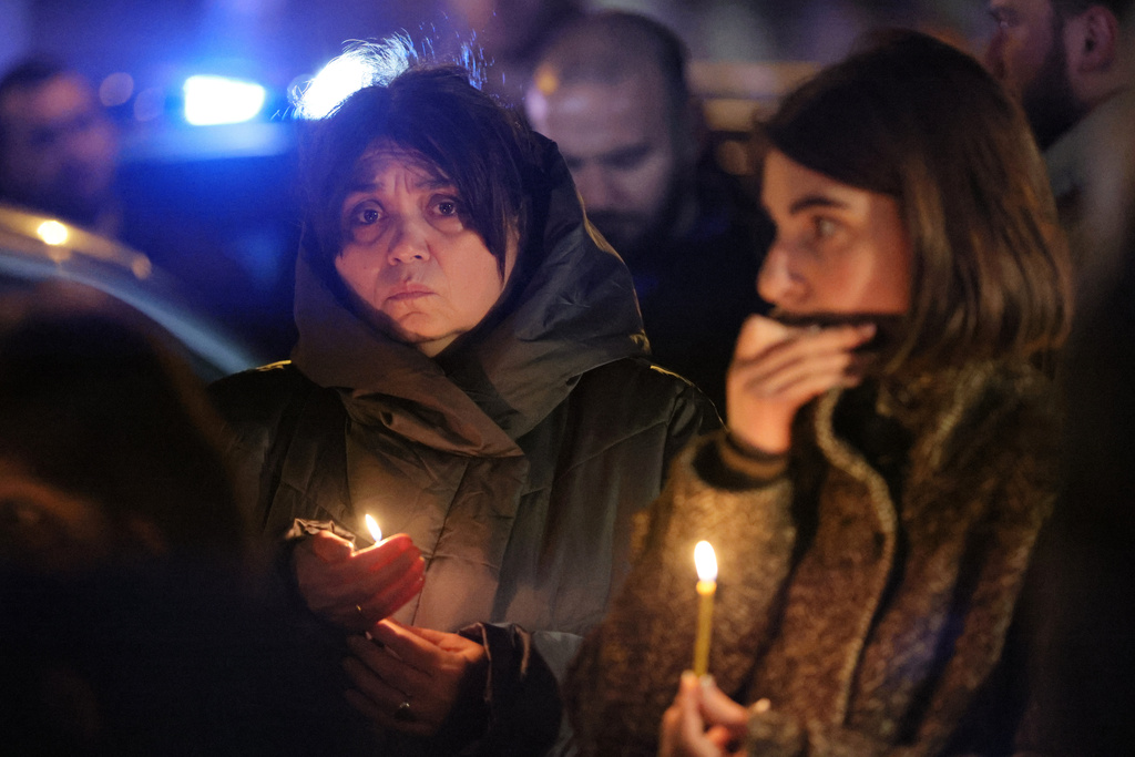 Georgian believers hold candles in memory of Georgian Orthodox Patriarch Ilia II at the hospital where he died in Tbilisi, Georgia, on Tuesday, March 17, 2026. (AP Photo/Zurab Tsertsvadze)
