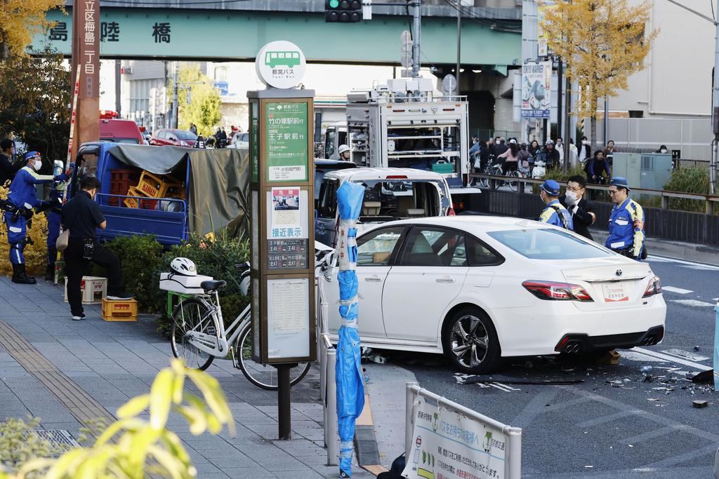 Investigators inspect the scene of a car accident injuring multiple people in Tokyo, Monday, Nov. 24, 2025. (Michi Ono/Kyodo News via AP)