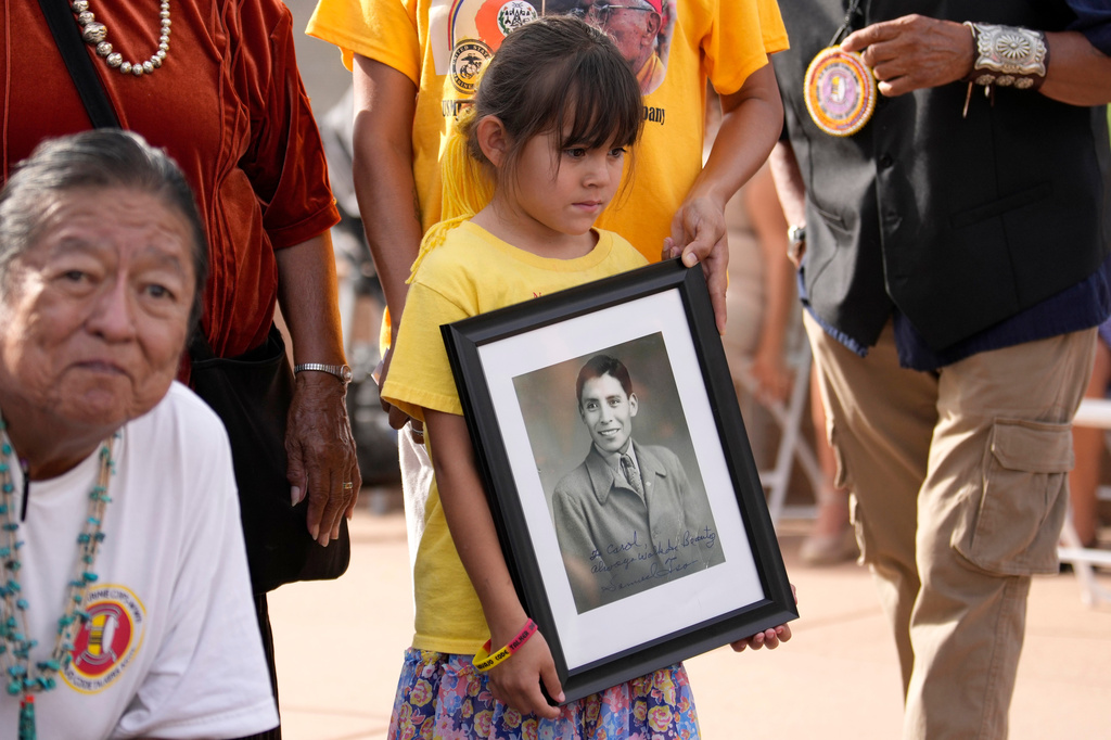 Descendants of Navajo Code Talkers, including family members of Samuel Nakai Tso, display his picture during a ceremony on Navajo Code Talkers Day, Friday, Aug. 14, 2026, in Phoenix. (AP Photo/Ross D. Franklin)