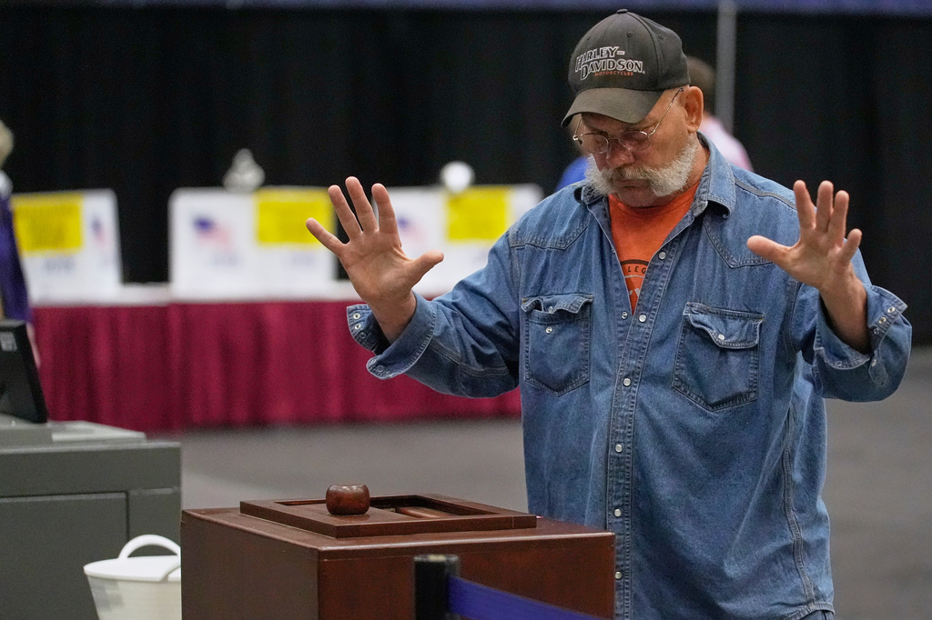 A Mainer reacts after his papers successfully dropped into to a ballot box while voting in the Maine Primary, Tuesday, June 9, 2026, in Augusta, Maine. (AP Photo/Robert F. Bukaty)