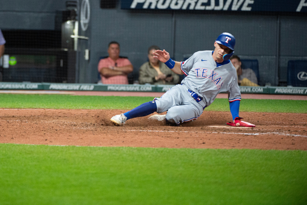 Texas Rangers' Michael Helman scores on a single by Cody Freeman off Cleveland Guardians relief pitcher Jakob Junis during the seventh inning of a baseball game, Friday, Sept. 26, 2025, in Cleveland. (AP Photo/Phil Long)