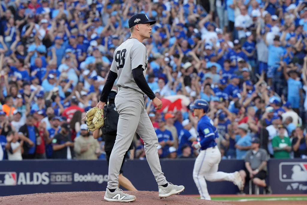 New York Yankees pitcher Will Warren, foreground, reacts as Toronto Blue Jays' Daulton Varsho, back right, rounds the bases after hitting a two-run home run during the fourth inning of Game 2 of baseball's American League Division Series in Toronto, Sunday, Oct. 5, 2025. (Frank Gunn/The Canadian Press via AP)