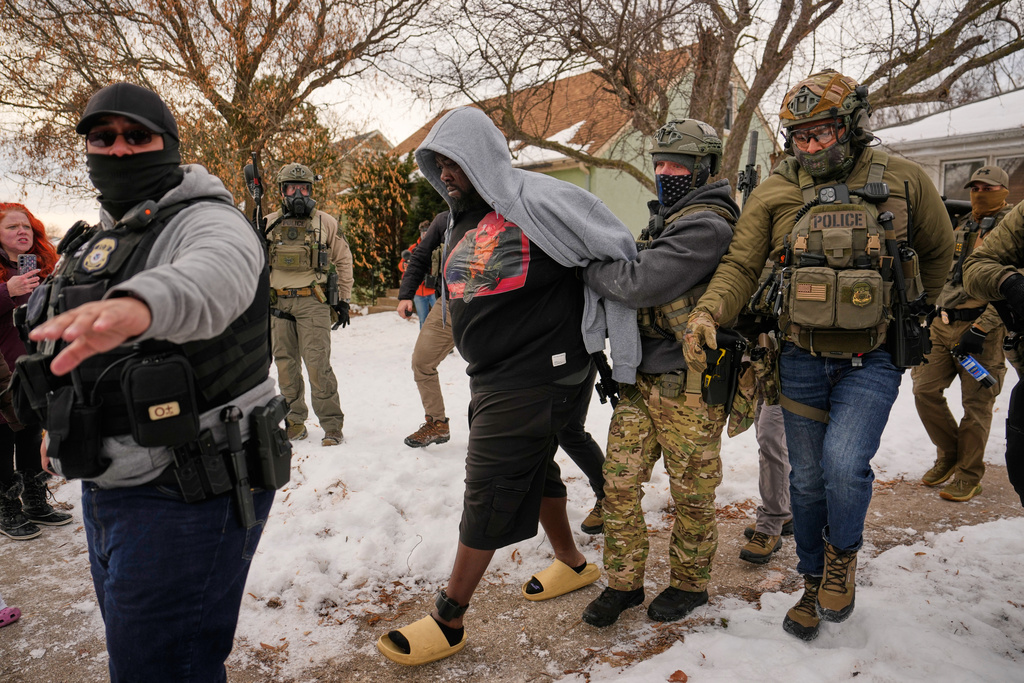 ADDS IDENTIFICATION: Garrison Gibson is arrested by federal immigration officers Sunday, Jan. 11, 2026, in Minneapolis. (AP Photo/John Locher)