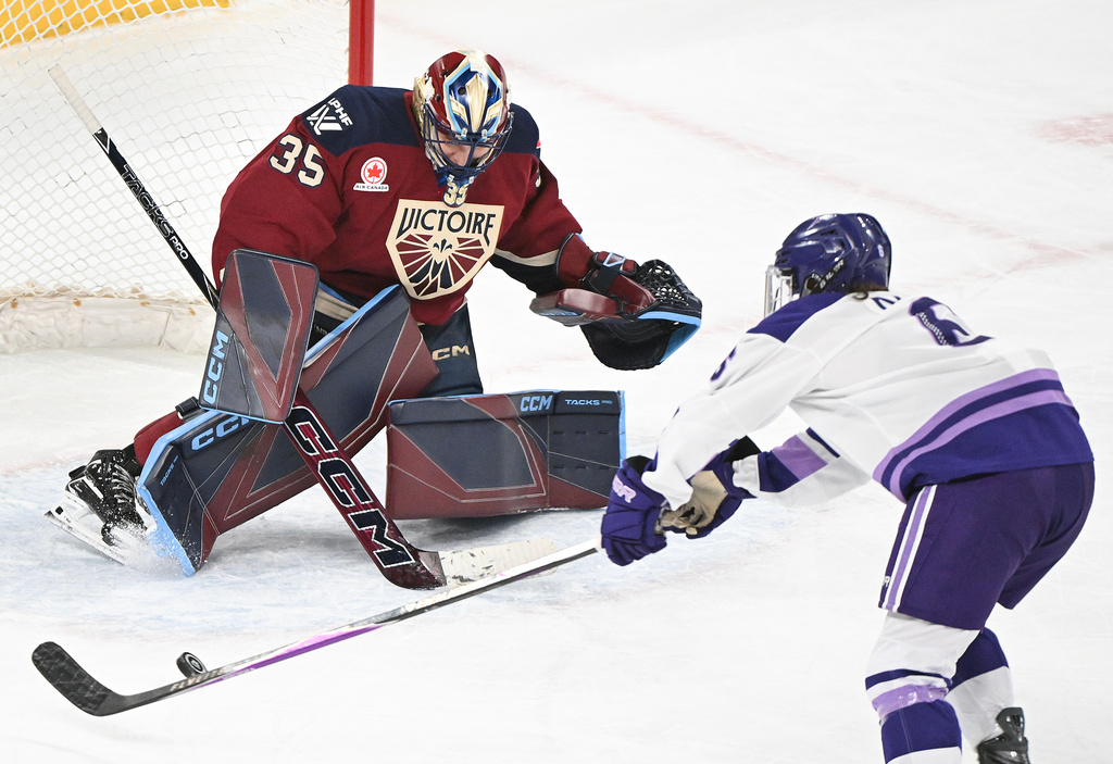 Minnesota Frost's Katy Knoll, right, moves in right Montreal Victoire goaltender Ann-Renee Desbiens (35) during second-period PWHL hockey game action in Laval, Quebec, Sunday, March 1, 2026. (Graham Hughes/The Canadian Press via AP)