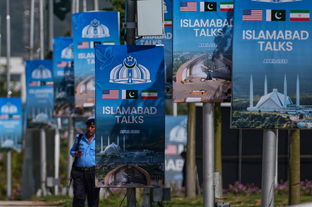 A police officer walks past billboards near the Serena Hotel ahead of the second round of negotiations between the U.S. and Iran, in Islamabad, Pakistan, Tuesday, April 21, 2026. (AP Photo/Anjum Naveed)