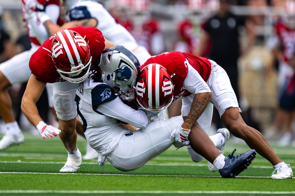 Howard wide receiver Antonio Hunter is hit by Indiana linebacker Isaiah Jones, left, and defensive back Byron Baldwin Jr. during the second half an NCAA college football game, Saturday, Sept. 12, 2026, in Bloomington, Ind. (AP Photo/Doug McSchooler)