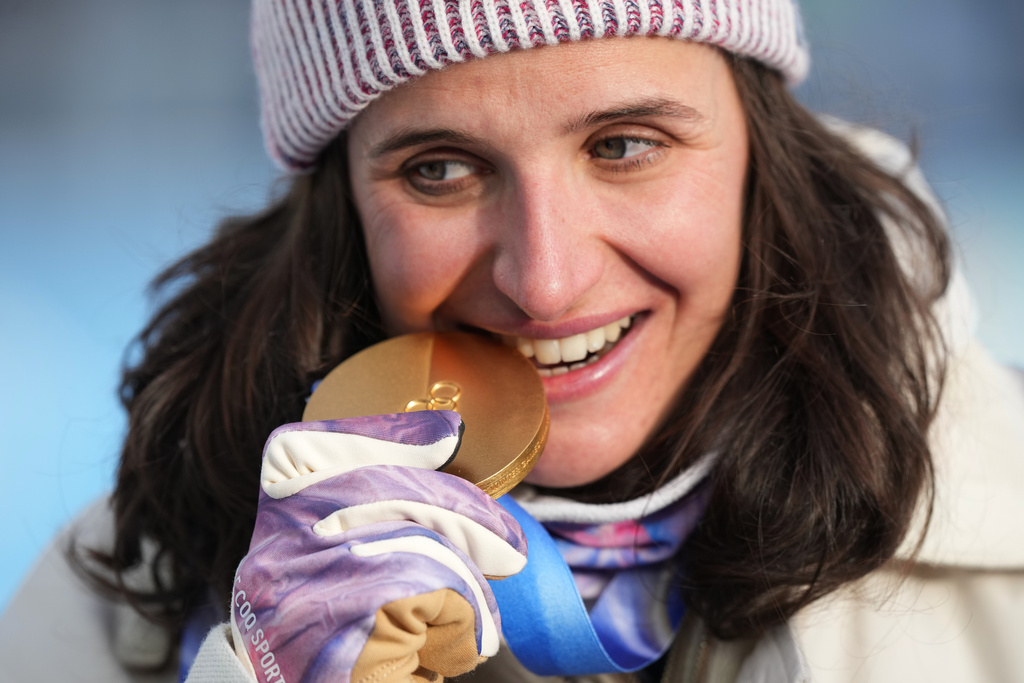 Julia Simon, of France, poses with the gold medal for the women's 15-kilometer individual biathlon race at the 2026 Winter Olympics in Anterselva, Italy, Wednesday, Feb. 11, 2026. (AP Photo/Andrew Medichini)