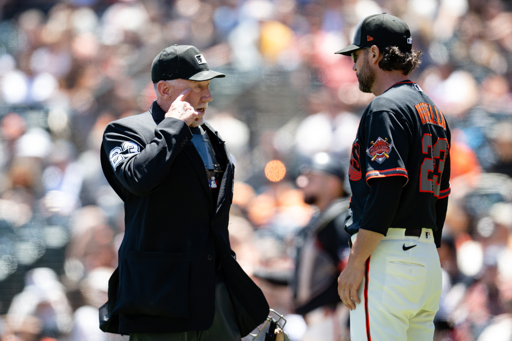 San Francisco Giants manager Tony Vitello (23), right, speaks with home plate umpire Lance Barksdale, left, after Colorado Rockies' Brett Sullivan (26) scores on a balk by San Francisco Giants pitcher Tyler Mahle during the third inning of a baseball game Saturday, July 11, 2026, in San Francisco. (AP Photo/Thien-An Truong)