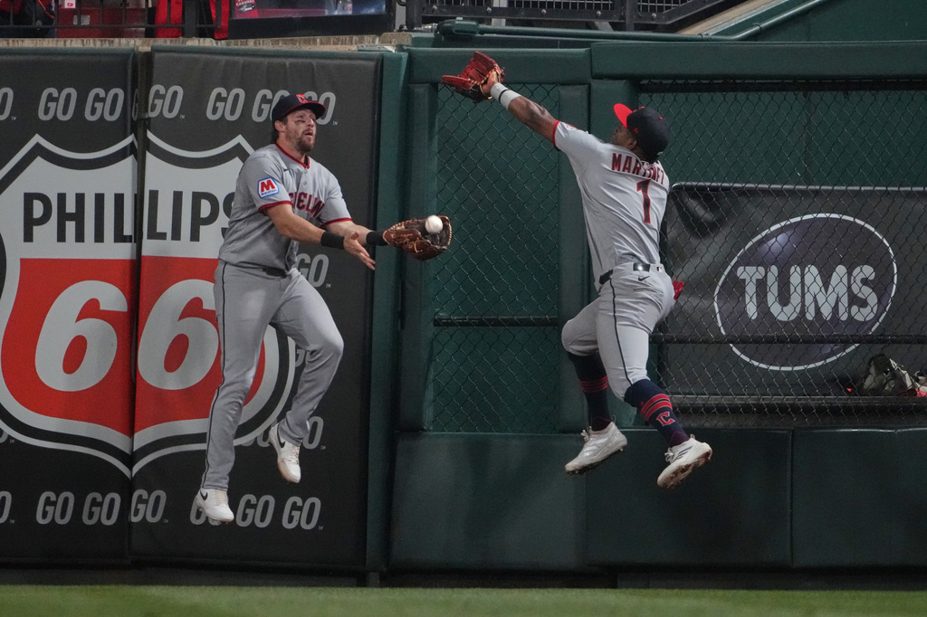 Cleveland Guardians center fielder Daniel Schneemann, left, catches a fly ball by St. Louis Cardinals' Alec Burleson as right fielder Angel Martínez (1) leaps but misses the ball to end the fifth inning of a baseball game Monday, April 13, 2026, in St. Louis. (AP Photo/Jeff Roberson)