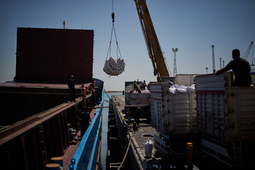 Workers offload cargo of rice from a feeder vessel into trucks at Umm Qasr Port, a deep-water port, in the city of Umm Qasr, Iraq, Friday, March 27, 2026. (AP Photo/Leo Correa)