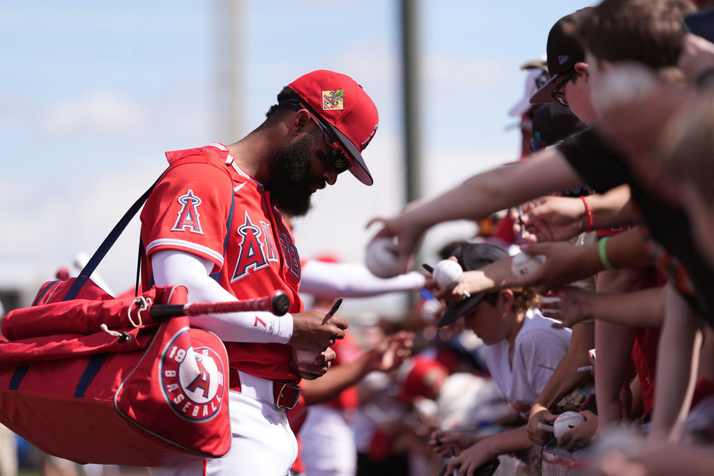 Los Angeles Angels' Jo Adell signs autographs prior to a spring training baseball game against the San Diego Padres Tuesday, March 10, 2026, in Tempe, Ariz. (AP Photo/Ross D. Franklin)