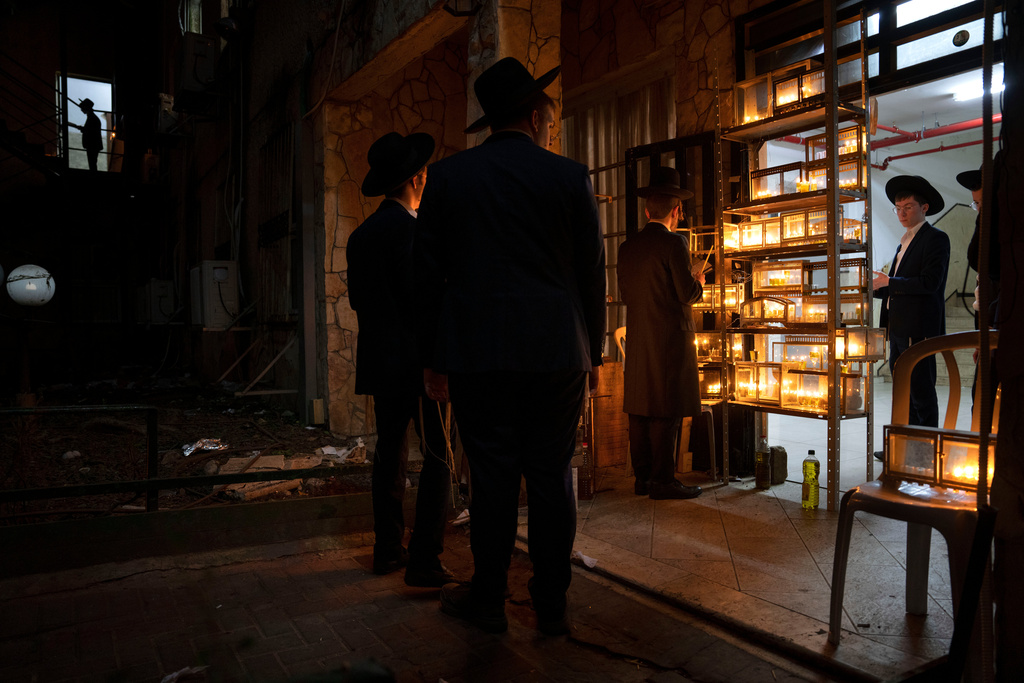 FILE - Ultra-Orthodox Jewish seminary students light candles on the third day of the Jewish holiday of Hanukkah in the ultra-Orthodox city of Bnei Brak near Tel Aviv, Israel, Tuesday, Dec. 20, 2022. (AP Photo/Oded Balilty, File)